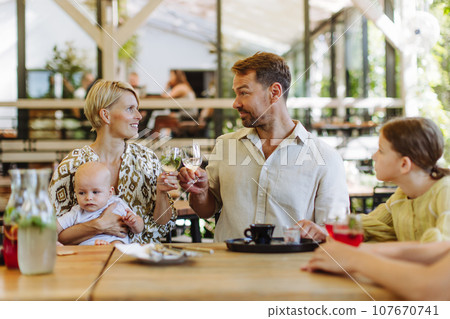 Big family with children and a small baby at family dinner in a restaurant. 107670741