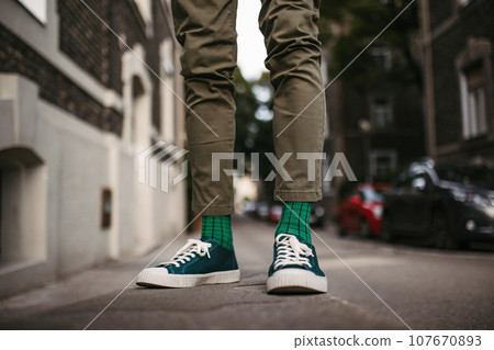 Close-up of a man's stylish shoes and quirky socks standing on the street. 107670893