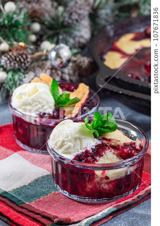 Berry cobbler in glass ramekin with ice cream, Christmas decoration, vertical Berry cobbler in glass ramekin with ice cream, Christmas decoration, vertical 107671836