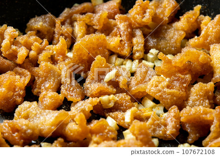 Leftover fried food remake image. A cooking scene where fried chicken skin is stir-fried with garlic. Leftover fried food remake image. A cooking scene where fried chicken skin is stir-fried with garlic. 107672108