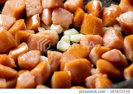 炒香腸和大蒜的烹飪場景。將香腸切碎,與大蒜一起炒。 炒香腸和大蒜的烹飪場景。將香腸切碎,與大蒜一起炒。 107672539