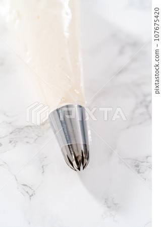 Metal tip with piping bag ready for buttercream frosting. 107675420