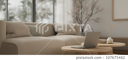 Close-up image of a laptop on a wooden minimal coffee table in a modern minimalist living room. Close-up image of a laptop on a wooden minimal coffee table in a modern minimalist living room. 107675482