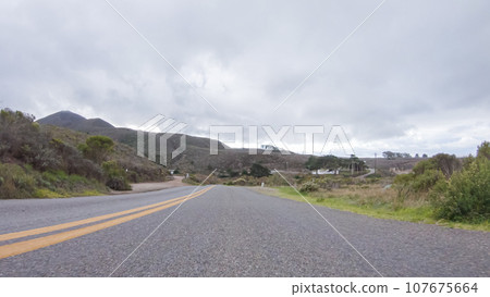 In this serene winter scene, a vehicle carefully makes its way along Los Osos Valley Road and Pecho Valley Road within Montana de Oro State Park. In this serene winter scene, a vehicle carefully makes its way along Los Osos Valley Road and Pecho Valley Road within Montana de Oro State Park. 107675664