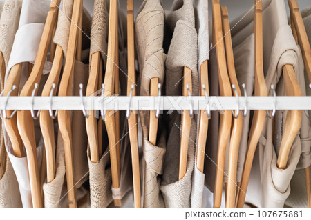 Hanger with neutral beige and white clothes on a white background. Hanger with neutral beige and white clothes on a white background. 107675881