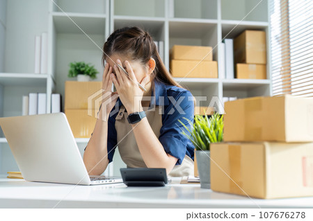 Young woman online business owner stress problem about preparing a parcel box to prepare the package for delivery to the customer Young woman online business owner stress problem about preparing a parcel box to prepare the package for delivery to the customer 107676278