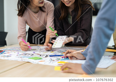 Team of ux developer and ui designer brainstorming interface wireframe design. Creative digital development agency 107676302