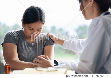 doctor therapist wearing white uniform with stethoscope touching frustrated patient shoulder doctor therapist wearing white uniform with stethoscope touching frustrated patient shoulder 107676306