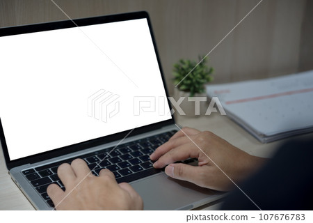 person hand using keyboard laptop computer mock up blank white screen on desk. person hand using keyboard laptop computer mock up blank white screen on desk. 107676783