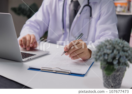 man doctor hand holding pen working information of patient in checklist paper on clipboard. Health care and insurance concept. 107677473