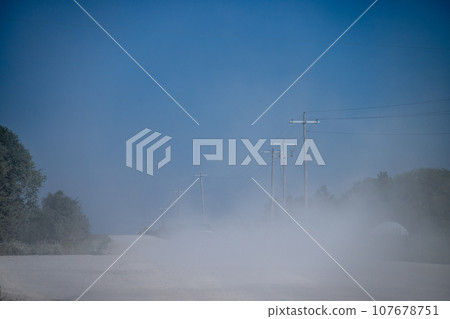 Dust on a gravel road after a vehicle passed 107678751