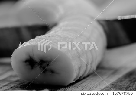 Selective focus on slices of a bananas on a wooden cutting board Selective focus on slices of a bananas on a wooden cutting board 107678790