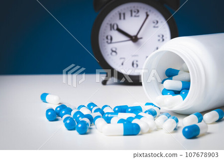 Time to take your medicine. Pill reminder. Tablets and alarm clock. Time to take your medicine. Pill reminder. Tablets and alarm clock. 107678903