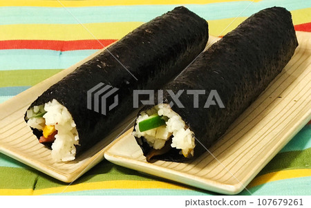 節分時,面對幸運方向,咬一口圓形卷,祈求好運。厚厚的捲,裡面充滿了手工製作的美味配料。 節分時,面對幸運方向,咬一口圓形卷,祈求好運。厚厚的捲,裡面充滿了手工製作的美味配料。 107679261