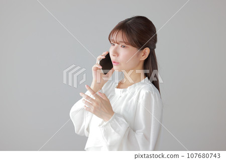 Young woman calling with a troubled expression 1 107680743