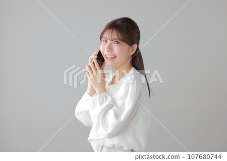 Young woman happily calling 1 107680744