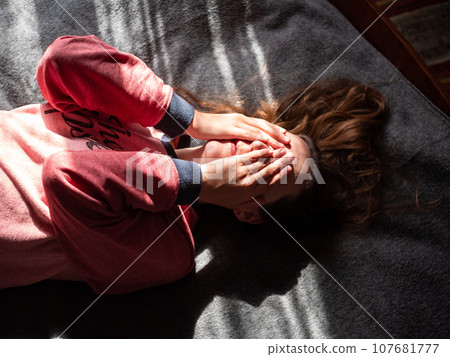 Stressed tired millennial woman on bed eyes closed suffers from headache Mental health Psychology Traumatic experience 107681777