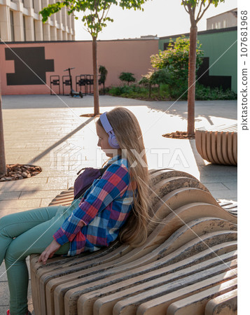 Blonde child headphones listening to music podcast smartphone outside Young girl online lesson audio book Mental health. Blonde child headphones listening to music podcast smartphone outside Young girl online lesson audio book Mental health. 107681968
