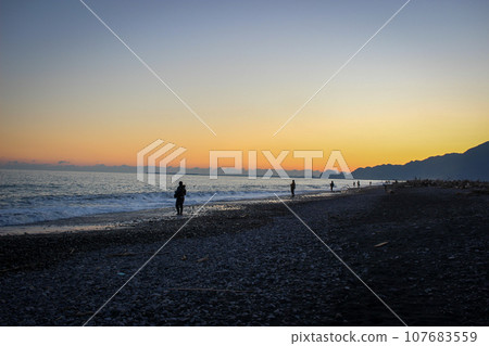 日落時海岸上的漁夫 107683559
