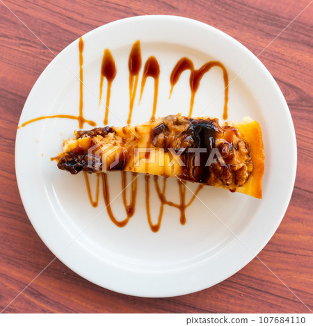 Piece of pie with walnuts served in a plate Piece of pie with walnuts served in a plate 107684110