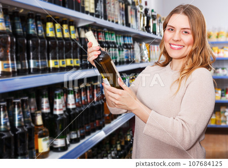 Female buying bottle of wine Female buying bottle of wine 107684125