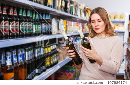 Female buying bottle of wine Female buying bottle of wine 107684174