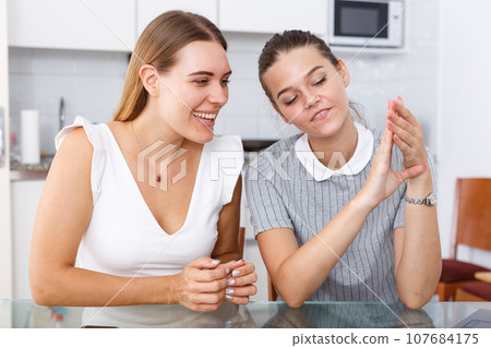 Girl showing ring to her friend Girl showing ring to her friend 107684175