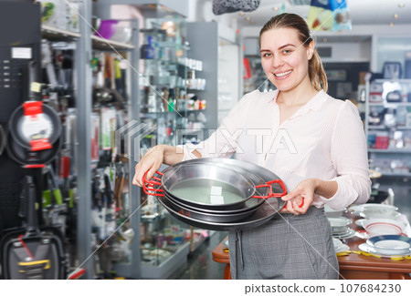 Adult woman is choosing set of stewpot 107684230