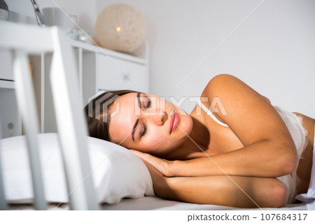 Woman sleeping in bed 107684317