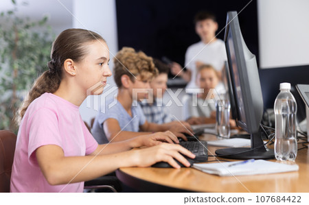 Girl student learning to work on computer in classroom Girl student learning to work on computer in classroom 107684422