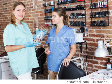 women nail masters standing at workplace 107684460