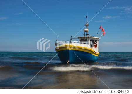 Fishing boat on the beach in Sopot, Poland. Magnificent long exposure calm Baltic Sea. Wallpaper defocused waves. Fishermans sea bay Vacation and holidays. travel attraction Fishing boat on the beach in Sopot, Poland. Magnificent long exposure calm Baltic Sea. Wallpaper defocused waves. Fishermans sea bay Vacation and holidays. travel attraction 107684660