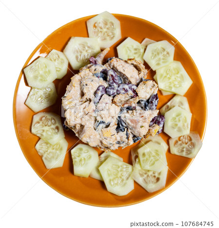 Salad made of beans, olives and chicken served in a plate with cucumber 107684745