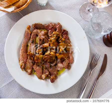 Sliced scottana beef tagliata with pan-fried white mushrooms Sliced scottana beef tagliata with pan-fried white mushrooms 107684776