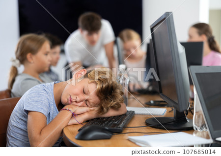 Boy student sleeps while sitting at computer 107685014