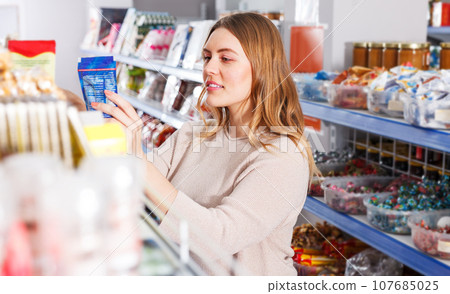 Woman choosing spices in grocery 107685025