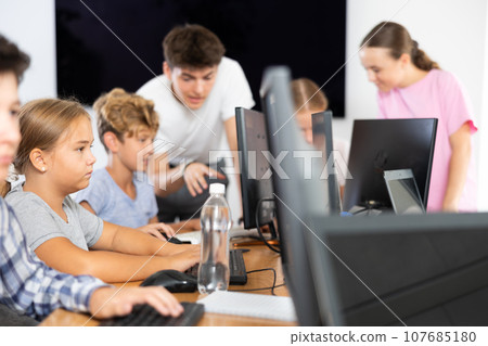 Portrait of female schoolgirl at computers in computer class Portrait of female schoolgirl at computers in computer class 107685180