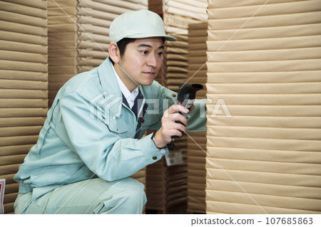 年輕工人在倉庫檢查行李 年輕工人在倉庫檢查行李 107685863