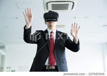 Young businessman watching VR in the office Young businessman watching VR in the office 107685948