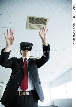 Young businessman watching VR in the office 107685952