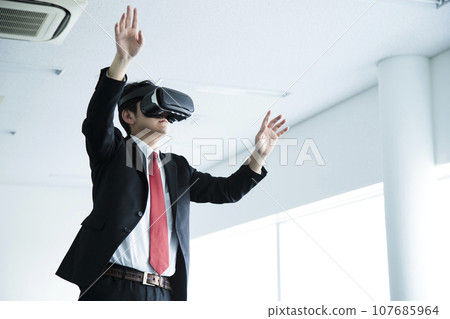 Young businessman watching VR in the office 107685964