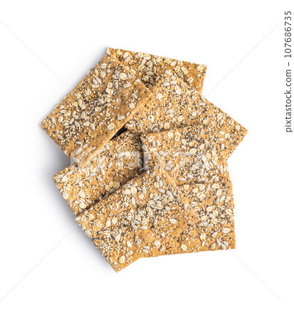 Knackebrot with sesame seeds. Wholegrain crispbread isolated on white background. Knackebrot with sesame seeds. Wholegrain crispbread isolated on white background. 107686735