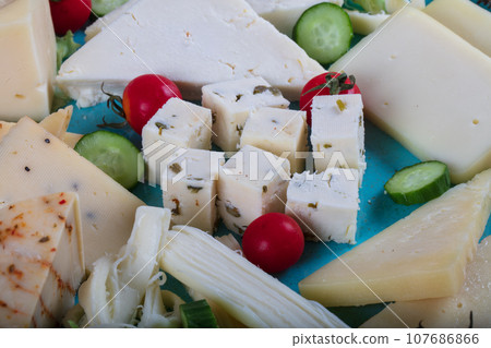 Cheese plate on a dark table. Many kinds of cheese on a plate. High quality photo Cheese plate on a dark table. Many kinds of cheese on a plate. High quality photo 107686866