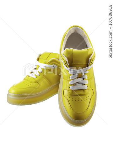 Infinitely beautiful leather sneakers made of canary yellow genuine leather, on a polyurethane translucent sole, with lacing, isolated on a white. Infinitely beautiful leather sneakers made of canary yellow genuine leather, on a polyurethane translucent sole, with lacing, isolated on a white. 107686918