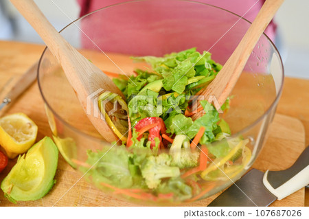 Overhead view a bowls of fresh vegetables salad on kitchen countertop. Healthy food, weight loss and dieting 107687026