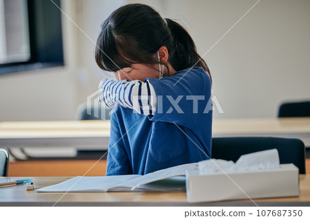 Elementary school girl holding her nose with clothes 107687350
