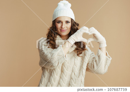 happy trendy woman showing heart hands isolated on beige happy trendy woman showing heart hands isolated on beige 107687739