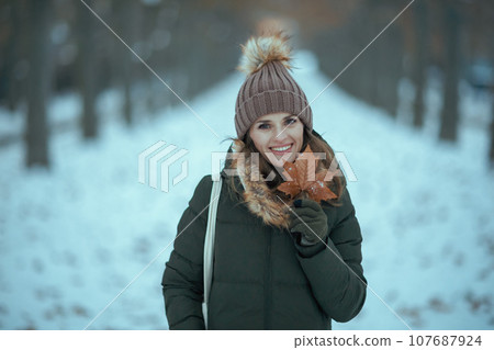 happy modern woman outdoors in city park in winter 107687924
