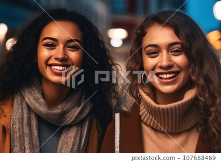 Two charming multiracial girls in autumn clothes are standing on a city street Two charming multiracial girls in autumn clothes are standing on a city street 107688469