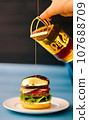 hand holding a burger with cheese and meat gold 107688709